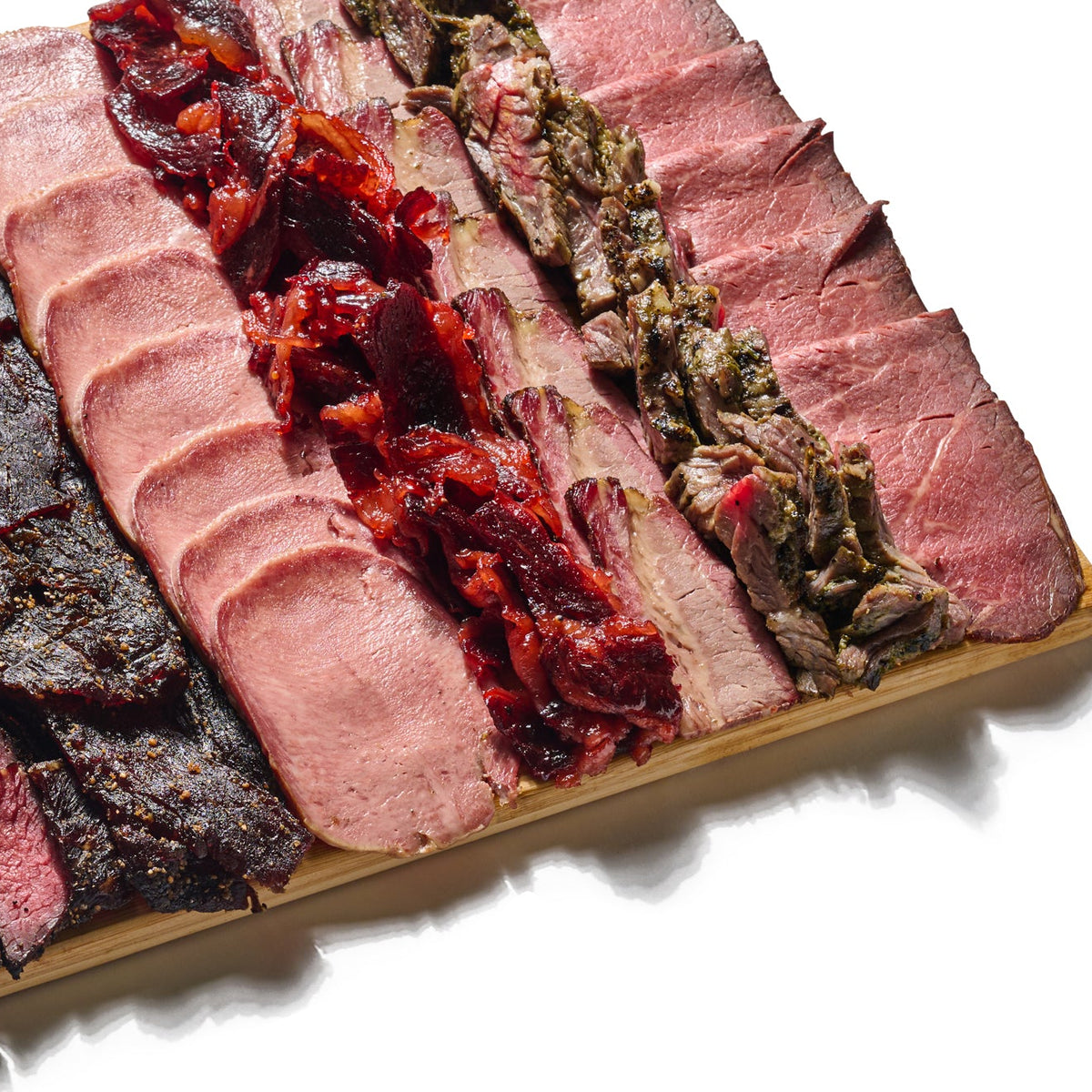 Next Level Taste Chef Special Board of sliced kosher deli meats on bamboo, white background