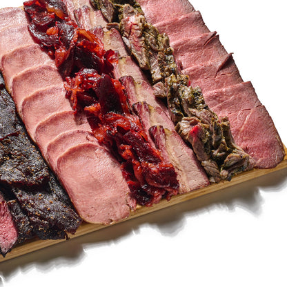 Next Level Taste Chef Special Board of sliced kosher deli meats on bamboo, white background